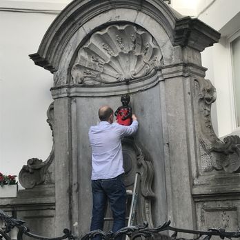 Manneken Pis - Someone putting one of the outfits on - Landmarks & Historical Buildings Near Me - Brussels, BRU