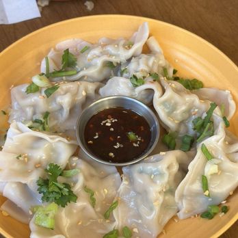 Formosa - Chicken dumplings - Plate of steamed dumplings garnished with green onions and cilantro, served with soy-based dipping sauce in a small metal cup. - Taiwanese Near Me - Brooklyn, New York