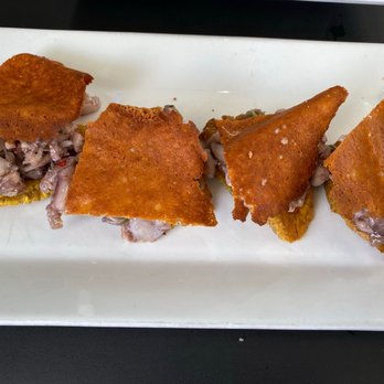 Ostra Cosa - Tostones arropaos (pulpo picado) - diced octopus covered with burnt cheese on top of plantain chip - Spanish Near Me - San Juan, Puerto Rico