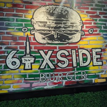 6ixside Burger - Cool art of the business in the back of the restaurant - A mural on a brick wall features a large burger illustration, colorful background, and the text '6 X SIDE BURGER' with a candle graphic. - Burgers Near Me - Pickering, Ontario