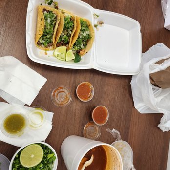 Mil Amores - a table with tacos, sauces, and condiments - Tacos Near Me - Roanoke, Texas