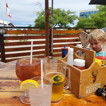 Growling Gator - a young boy sitting at a table with a box of ketchup and a glass of iced tea - Burgers Near Me - Grand Bend, Ontario
