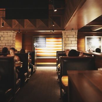 Houston's Restaurant - Interior dining space. Warm lighting and cozy booths. - New American Near Me - Irvine, California