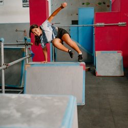 Freedom In Motion Parkour Gym - Murrieta - Girl vaulting through the obstacle course during her parkour class at Freedom in Motion parkour gym in Murritea