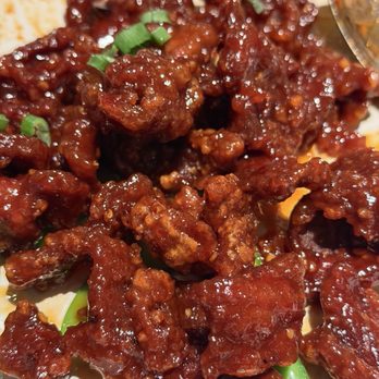 Panda Inn - Panda Beef - A dish of sweet and sour pork with crispy pieces coated in a glossy sauce, garnished with chopped green onions. - Chinese Near Me - Pasadena, California