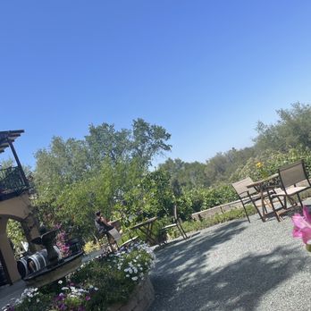 Cristaldi Vineyards - a patio area with flowers in the foreground - Wineries Near Me - Loomis, California