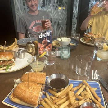Makers Union - French dip, with a couple fried chicken sandwiches in the background - American Near Me - Arlington, Virginia Makers Union - French dip, with a couple fried chicken sandwiches in the background - American Near Me - Arlington, Virginia