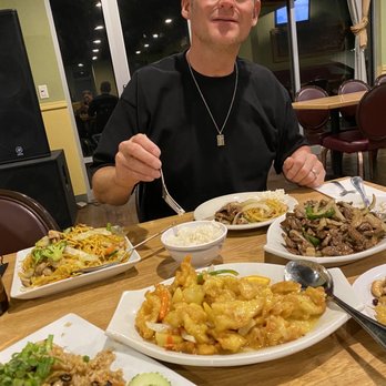 Bangkok Restaurant - a man sitting at a table full of food - Thai Near Me - Kennewick, Washington Bangkok Restaurant - a man sitting at a table full of food - Thai Near Me - Kennewick, Washington