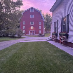 Robinson Farm - Golden hour at the Farmhouse, with the barn glowing in the background. A peaceful setting for your next Vermont stay.
