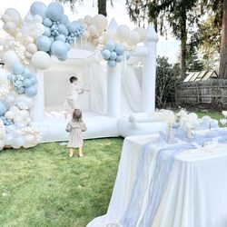 Chateau Bounce & Balloons - Luxury white bounce house rental with balloon garlands, kids' table setup, & elegant outdoor party styling. Perfect for birthdays parties.
