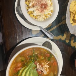 Chicken soup with avocado and an elote type bowl. Chicken soup with avocado and an elote type bowl.