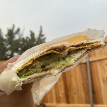 Taco Bell - a hand holding a half eaten sandwich - Fast Food Near Me - Yreka, California Taco Bell - a hand holding a half eaten sandwich - Fast Food Near Me - Yreka, California