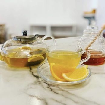 Café Bloom - a cup of tea and a teapot on a marble table - Desserts Near Me - Benton, Illinois