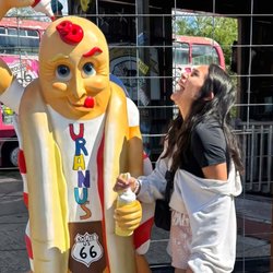 Woman laughing at a photo op statue in Uranus.