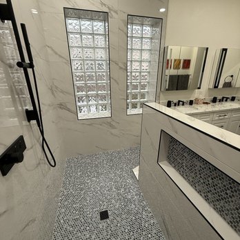 Better Bath Remodeling - Primary Bath 3 - A bathroom shower features glass block windows, marble walls, and a pebble tile floor with a drain. - General Contractors Near Me - Tempe, Arizona