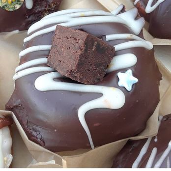 Vegan Sunshine Donuts - a chocolate donut with a bite taken out of it - Donuts Near Me Vegan Sunshine Donuts - a chocolate donut with a bite taken out of it - Donuts Near Me