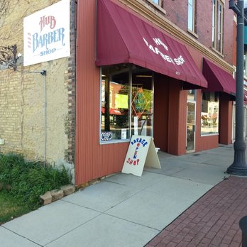 Hub Barber Shop - Showing the board sign on the North side of the building, the awning and the sandwich board sign. - Hair Salons Near Me - Belvidere, Illinois Hub Barber Shop - Showing the board sign on the North side of the building, the awning and the sandwich board sign. - Hair Salons Near Me - Belvidere, Illinois