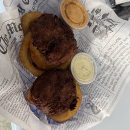 Overly fried crab cakes on top of onion rings Overly fried crab cakes on top of onion rings