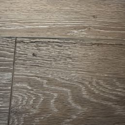 Cracking vinyl floor plank with an attempt at a patch by drilled a hole and injecting material underneath. Cracking vinyl floor plank with an attempt at a patch by drilled a hole and injecting material underneath.