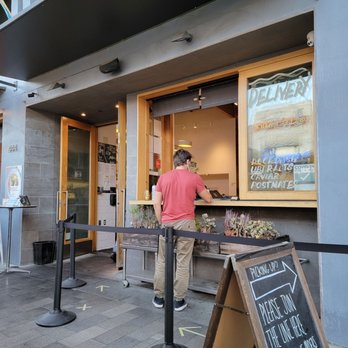 Delfina - a man at the counter - Pizza Near Me - San Francisco, California