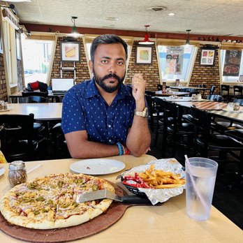 Pizza Hut - a man sitting at a table with two pizzas - Pizza Near Me - Chadron, Nebraska Pizza Hut - a man sitting at a table with two pizzas - Pizza Near Me - Chadron, Nebraska