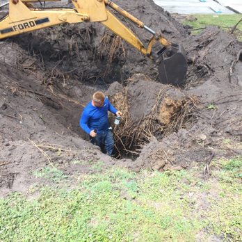 Clean Cut Tree Service & Stump Grinding, Inc - a man digging a hole - Landscaping Near Me - Melbourne, Florida Clean Cut Tree Service & Stump Grinding, Inc - a man digging a hole - Landscaping Near Me - Melbourne, Florida