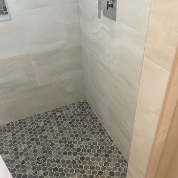 Simplicity Bath and Shower - a shower with a hexagon tile floor - General Contractors Near Me