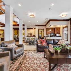 The Lodge at Peasley Canyon - Resident lounge area with a brown leather couch and a coffee table at The Lodge at Peasley Canyon, Federal Way, WA