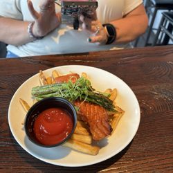 Salmon laying on fries topped w/asparagus. Yeah, asparagus will class it up!!
