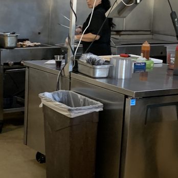 WaBa Grill - a woman preparing food in a commercial kitchen - Fast Food Near Me - Indio, California WaBa Grill - a woman preparing food in a commercial kitchen - Fast Food Near Me - Indio, California