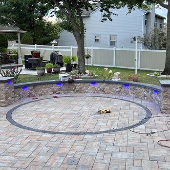 Lavish Gardens NJ - a brick patio with a circular fire pit - Landscaping Near Me Lavish Gardens NJ - a brick patio with a circular fire pit - Landscaping Near Me