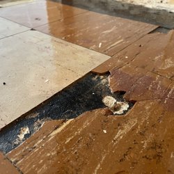 A 1 Abatement - before photo: example of broken and disintegrating asbestos tile.