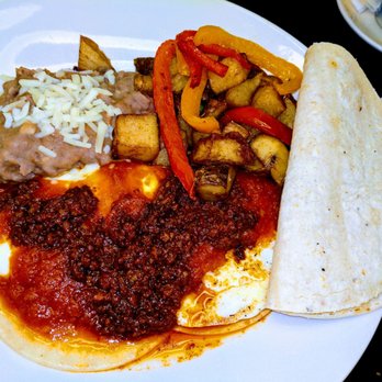 The Griffin Grill - Huevos Rancheros - fried eggs served on tortillas w/ roasted Ranchero sauce served w/ refried beans and potatoes. Added house-made chorizo. - American Near Me - Mission, Texas