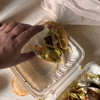 Roman's Mexi-Cali Grill - Falling apart, hard shell taco that was just bought. - Mexican Near Me - Huntington Beach, California