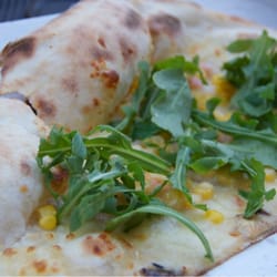 Noi e Voi - Pizza bianca con rucola e mais. Il nome della pizza nel menù è Maya.