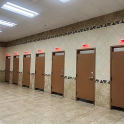 Solid walls between stalls with red or green lights above the door indicating vacancy or not. Nice!