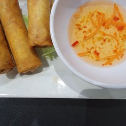 a bowl of soup and three spring rolls