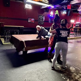 Coyote Ugly Saloon - a group of people playing a game of pool - Dive Bars Near Me - Memphis, Tennessee