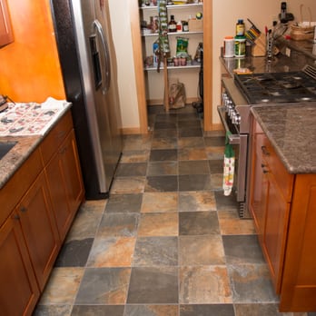 Integral Tile - a kitchen with granite countertops and a stainless steel refrigerator - Flooring Near Me Integral Tile - a kitchen with granite countertops and a stainless steel refrigerator - Flooring Near Me