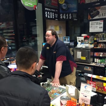 Chevron - a man standing at a cash register in a store - Gas Stations Near Me - Alhambra, California