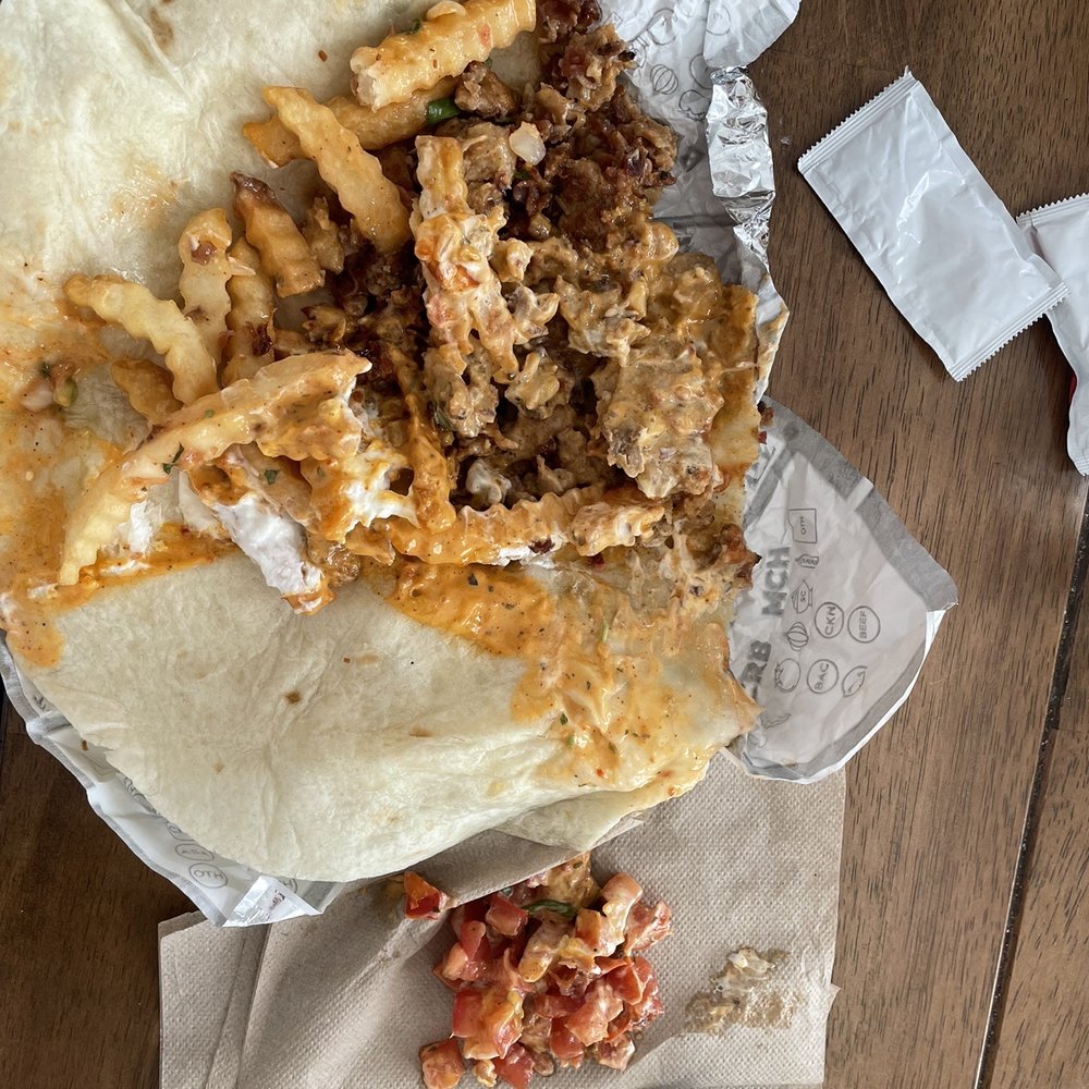 a burrito and a fork on a napkin