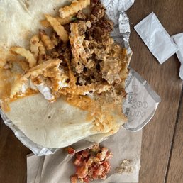 a burrito and a fork on a napkin