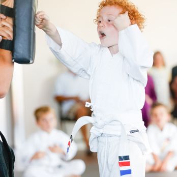 SwiftKick Martial Arts Carlsbad - Young white belt martial artist punching a pad. - Martial Arts Near Me - Carlsbad, California SwiftKick Martial Arts Carlsbad - Young white belt martial artist punching a pad. - Martial Arts Near Me - Carlsbad, California