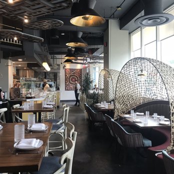 Agora Tysons - Unique tables - half moons with canopy cover -towards front entrance by bar area. - Mediterranean Near Me - Tysons, Virginia Agora Tysons - Unique tables - half moons with canopy cover -towards front entrance by bar area. - Mediterranean Near Me - Tysons, Virginia