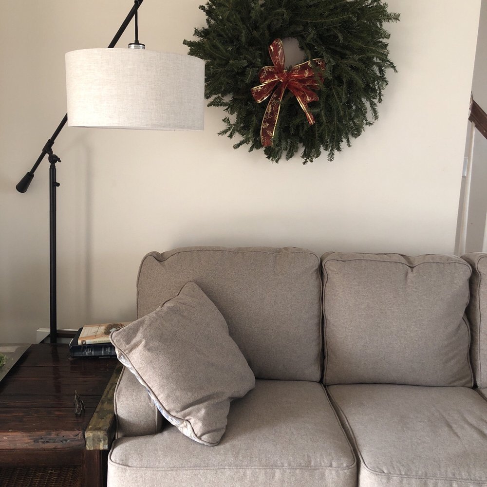 a wreath on a wall above a couch