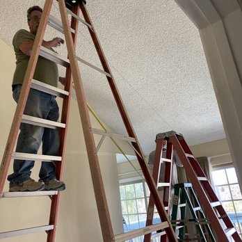 Ceiling Master - a man standing on a ladder - General Contractors Near Me