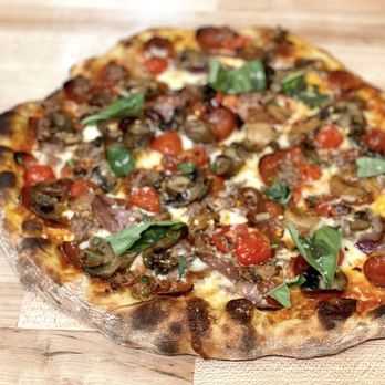 Saint Bibiana - a pizza on a wooden table - Pizza Near Me - Santa Barbara, California Saint Bibiana - a pizza on a wooden table - Pizza Near Me - Santa Barbara, California
