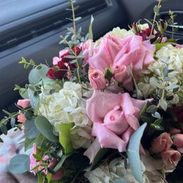 Hydrangeas, pink roses, red rose buds, and a mix of greenery. Hydrangeas, pink roses, red rose buds, and a mix of greenery.
