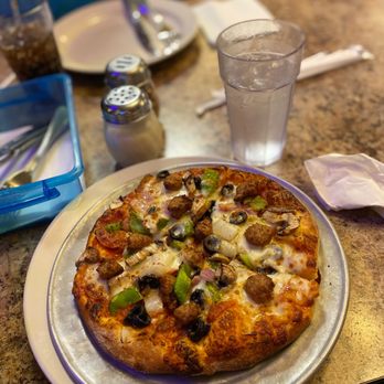 Sahara Pizza - a pizza on a plate on a table - Pizza Near Me - Sultan, Washington Sahara Pizza - a pizza on a plate on a table - Pizza Near Me - Sultan, Washington