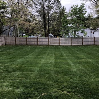 Fenway Landscaping - a backyard with a fence and grass - Landscaping Near Me